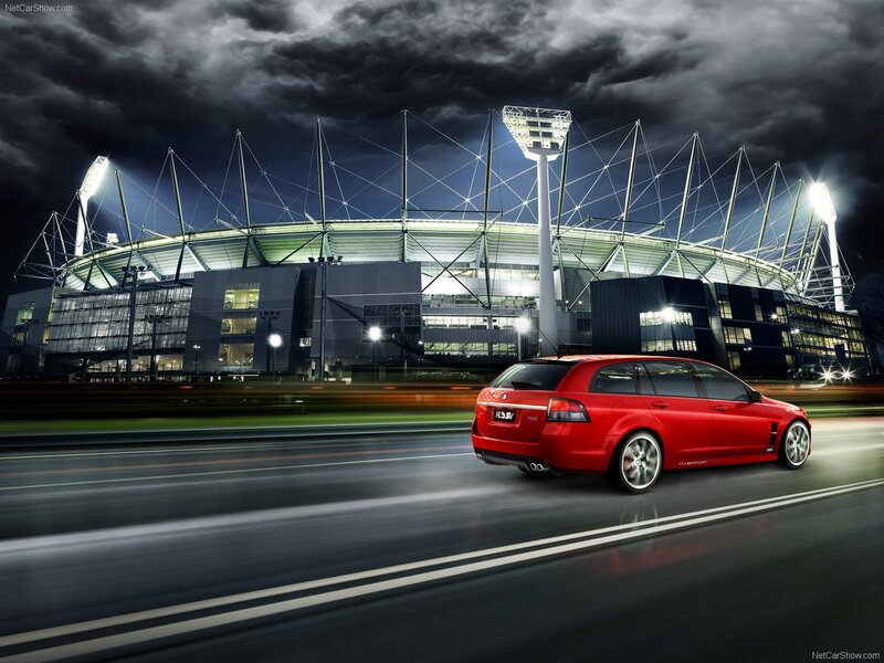 Red car at night near stadium