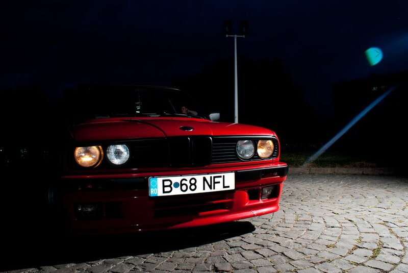 Red car at night on cobblestones
