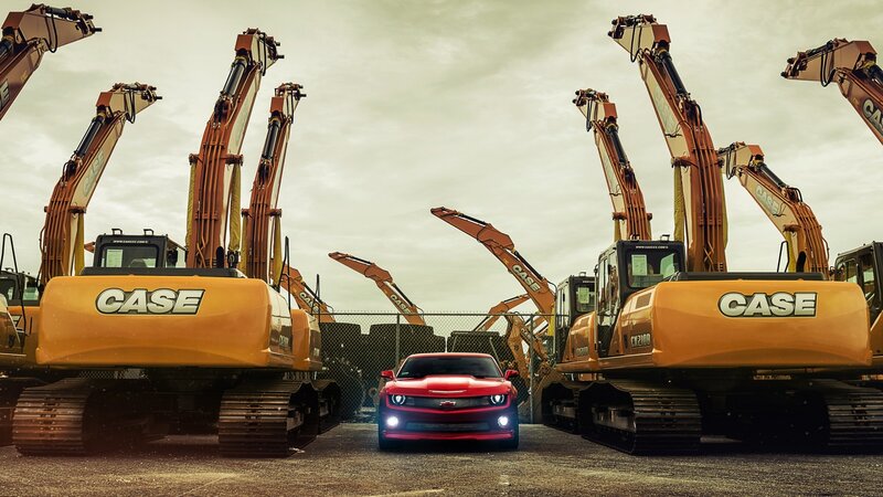 Red car between excavators