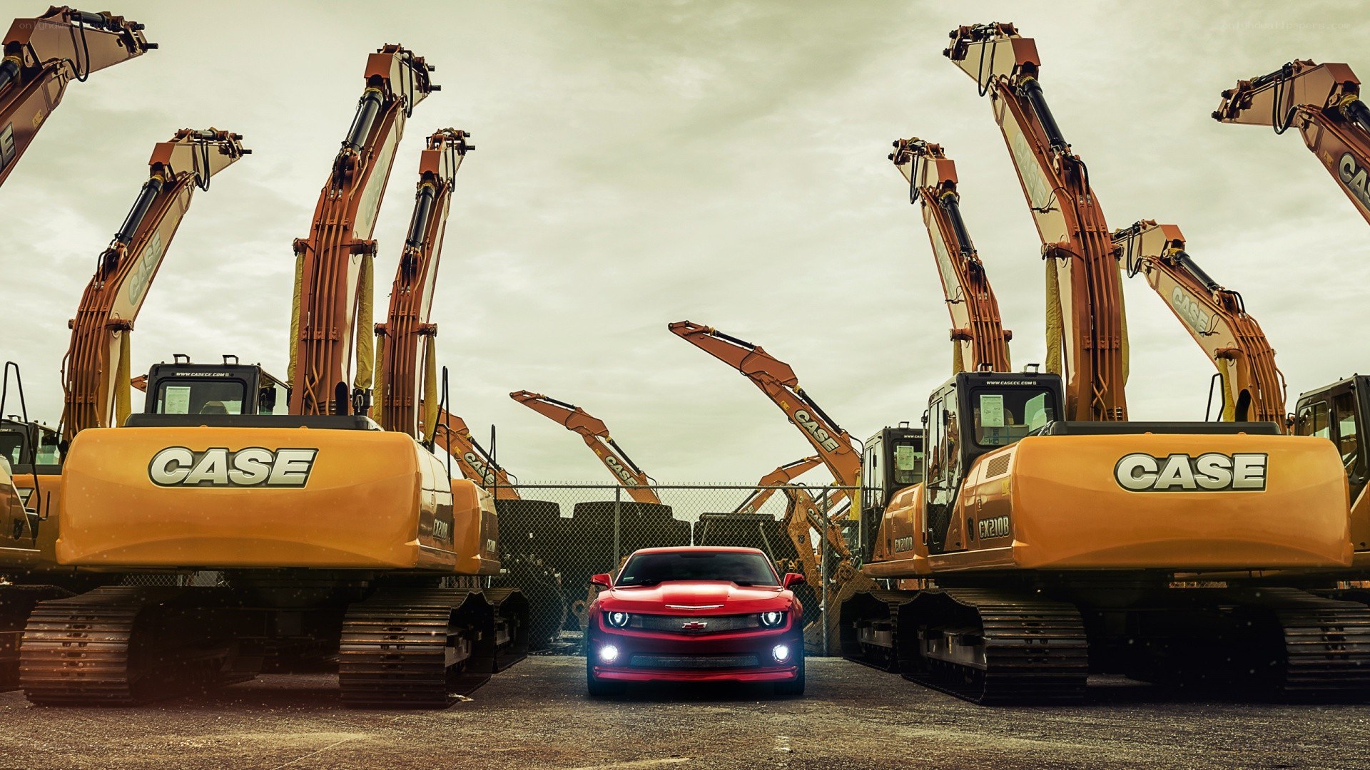 Red car between excavators