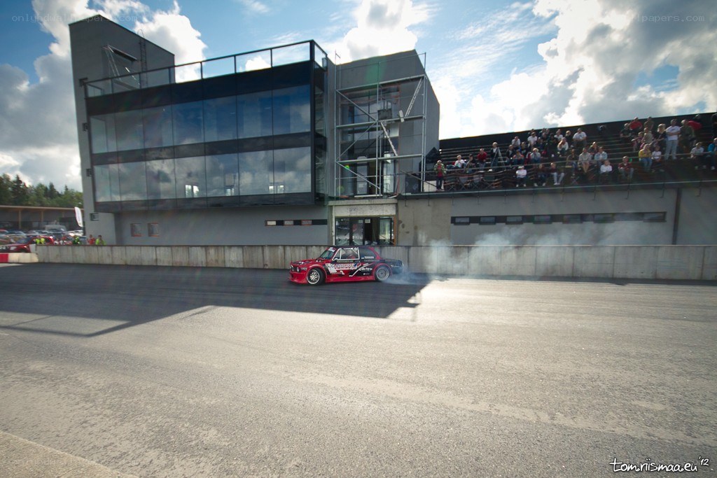 Red car drifting at racetrack