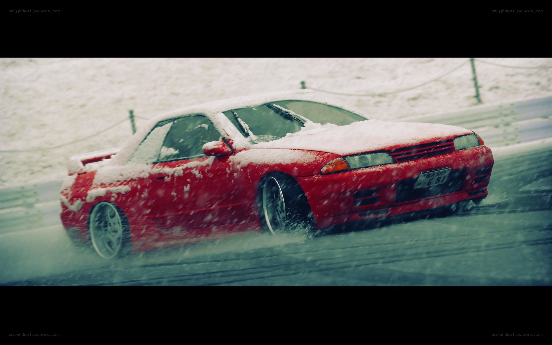 Red car drifting in snow