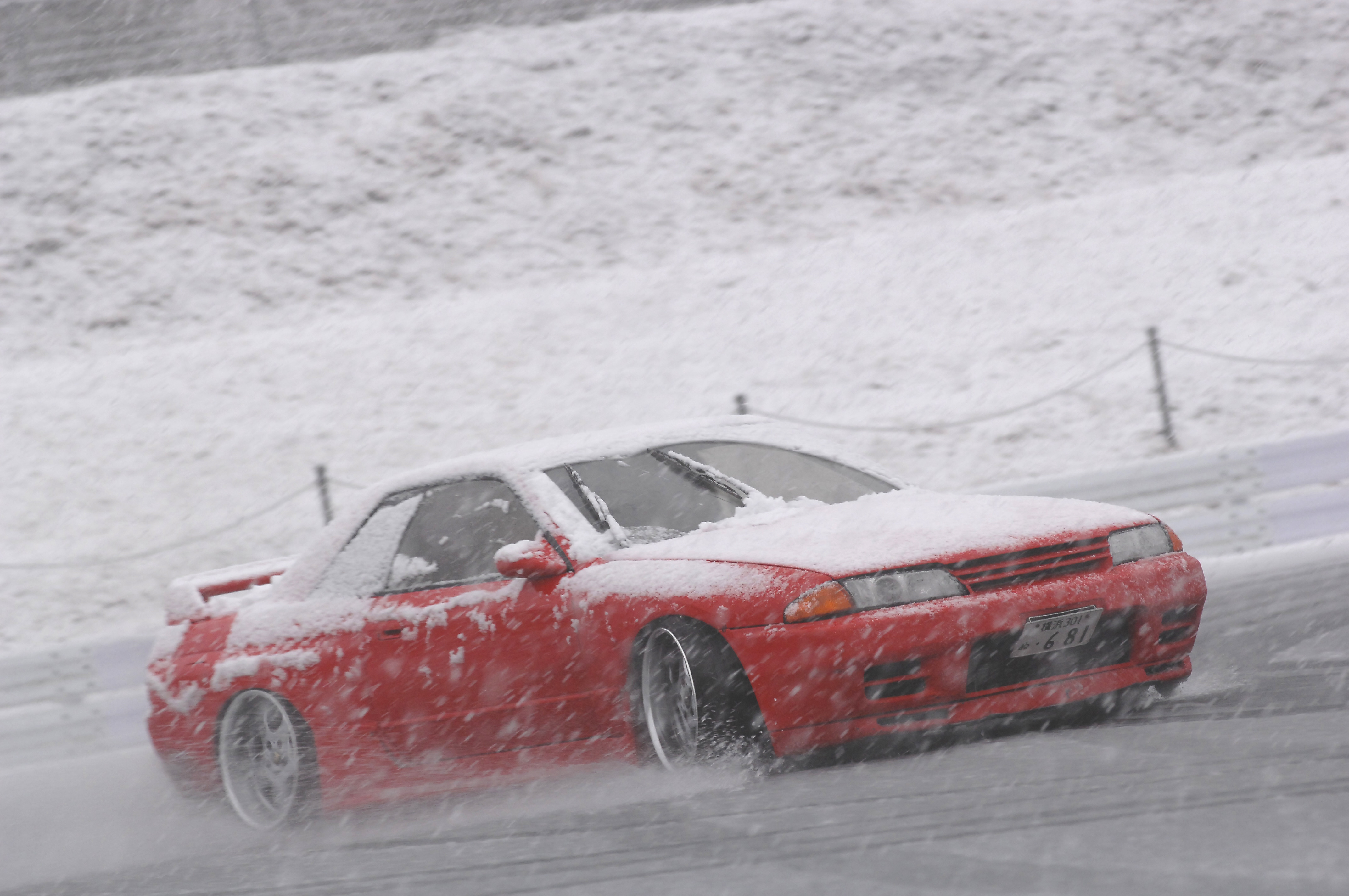 Red car drifting in snow