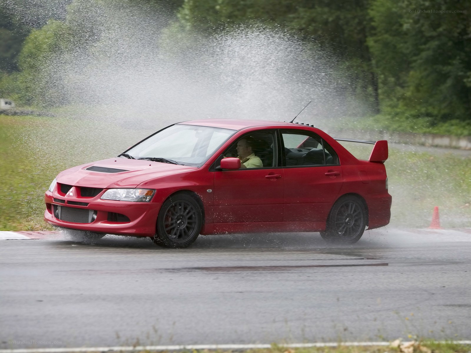Red car drifting on wet track