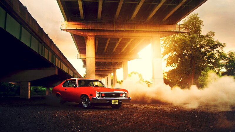 Red car drifting under bridge