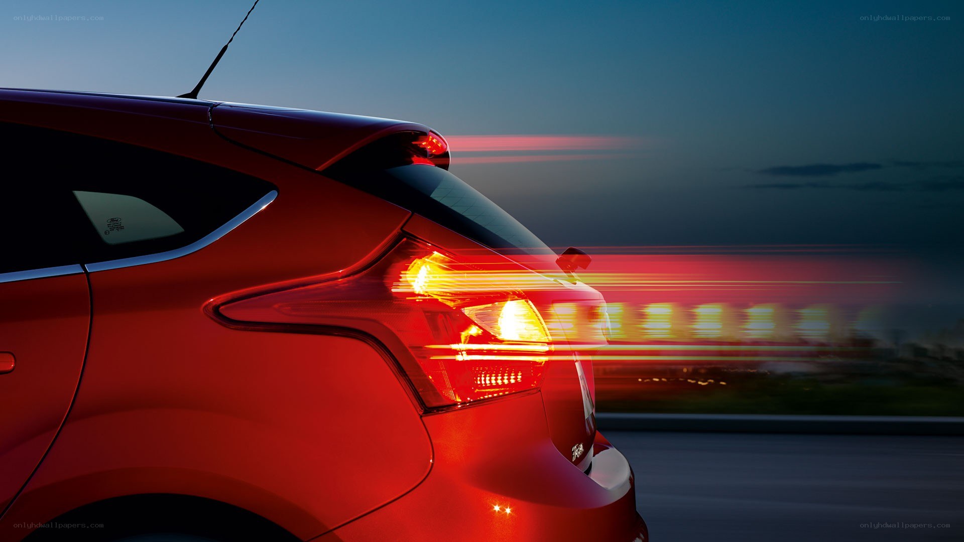 Red car driving at dusk