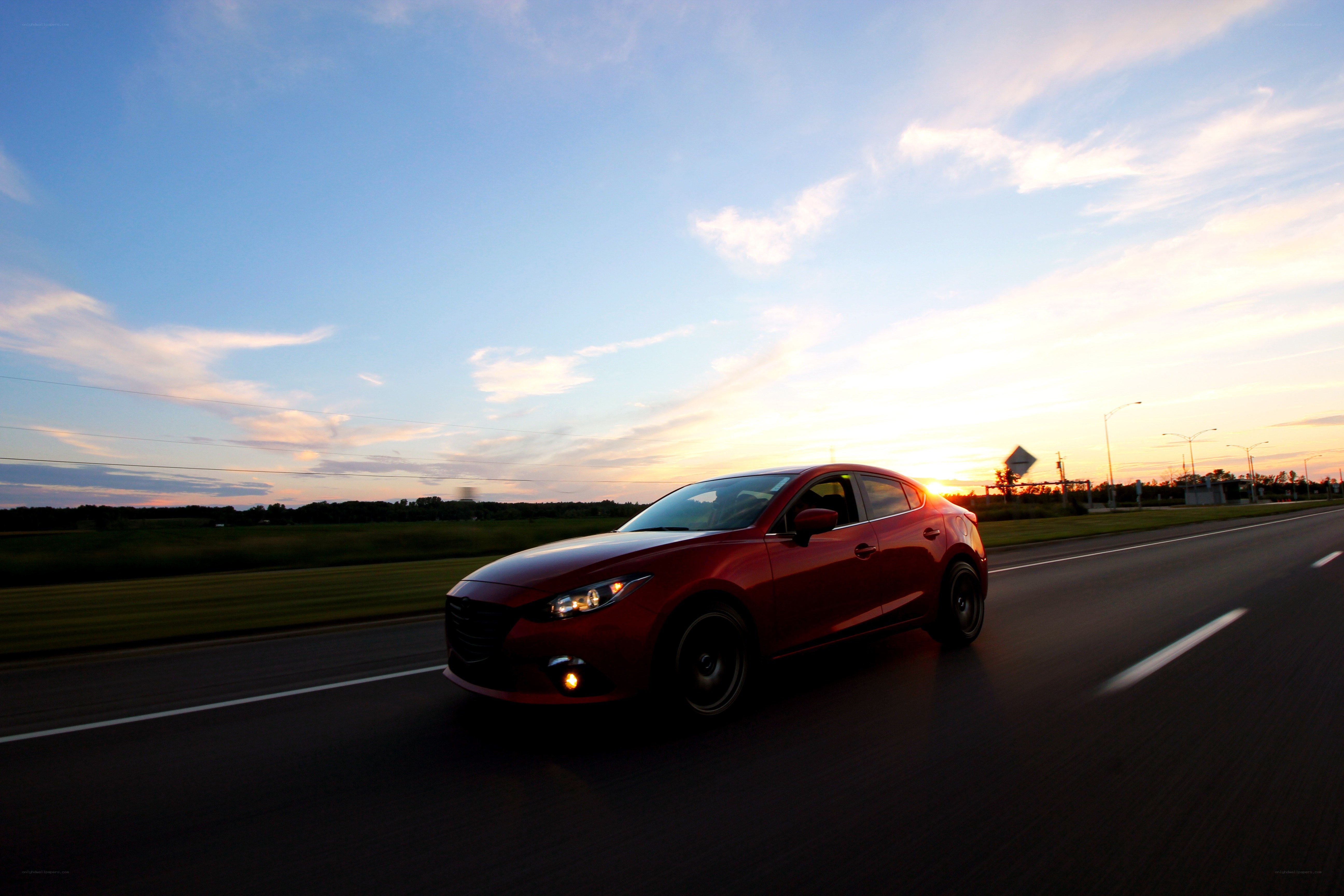 Red car driving at sunset