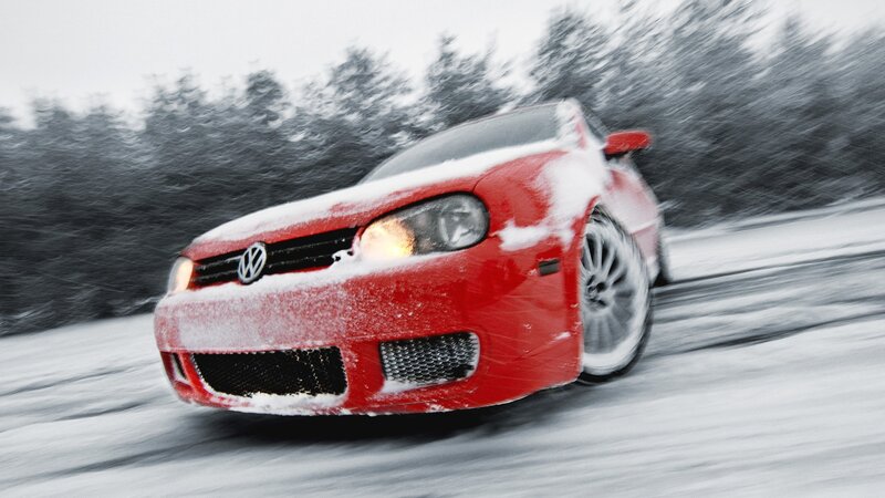 Red car driving in snow