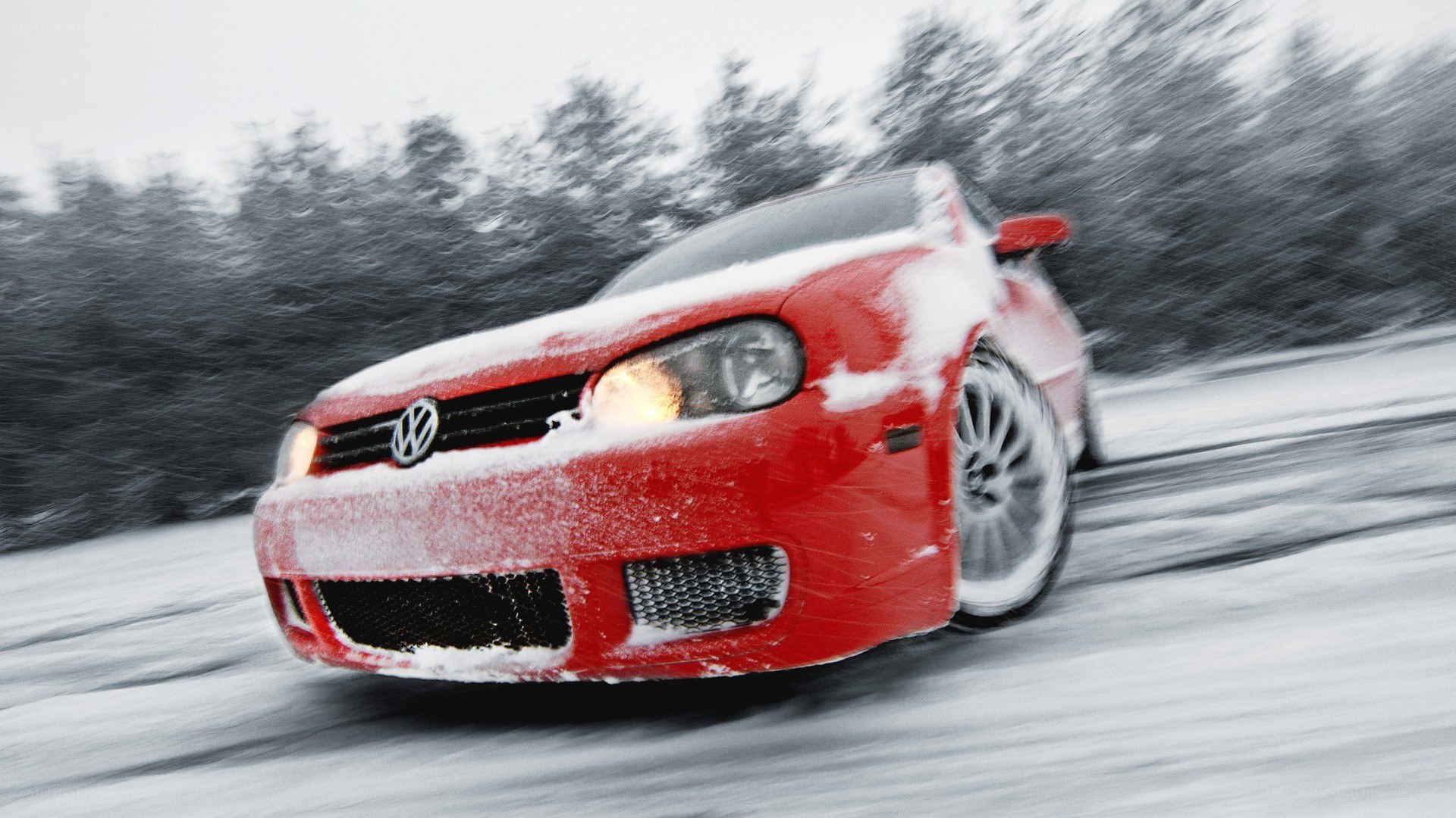 Red car driving in snow