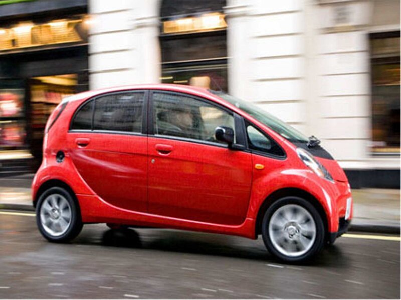 red car driving on city street