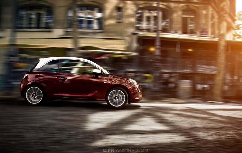 Red car driving on city street