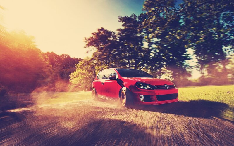 Red car driving on country road