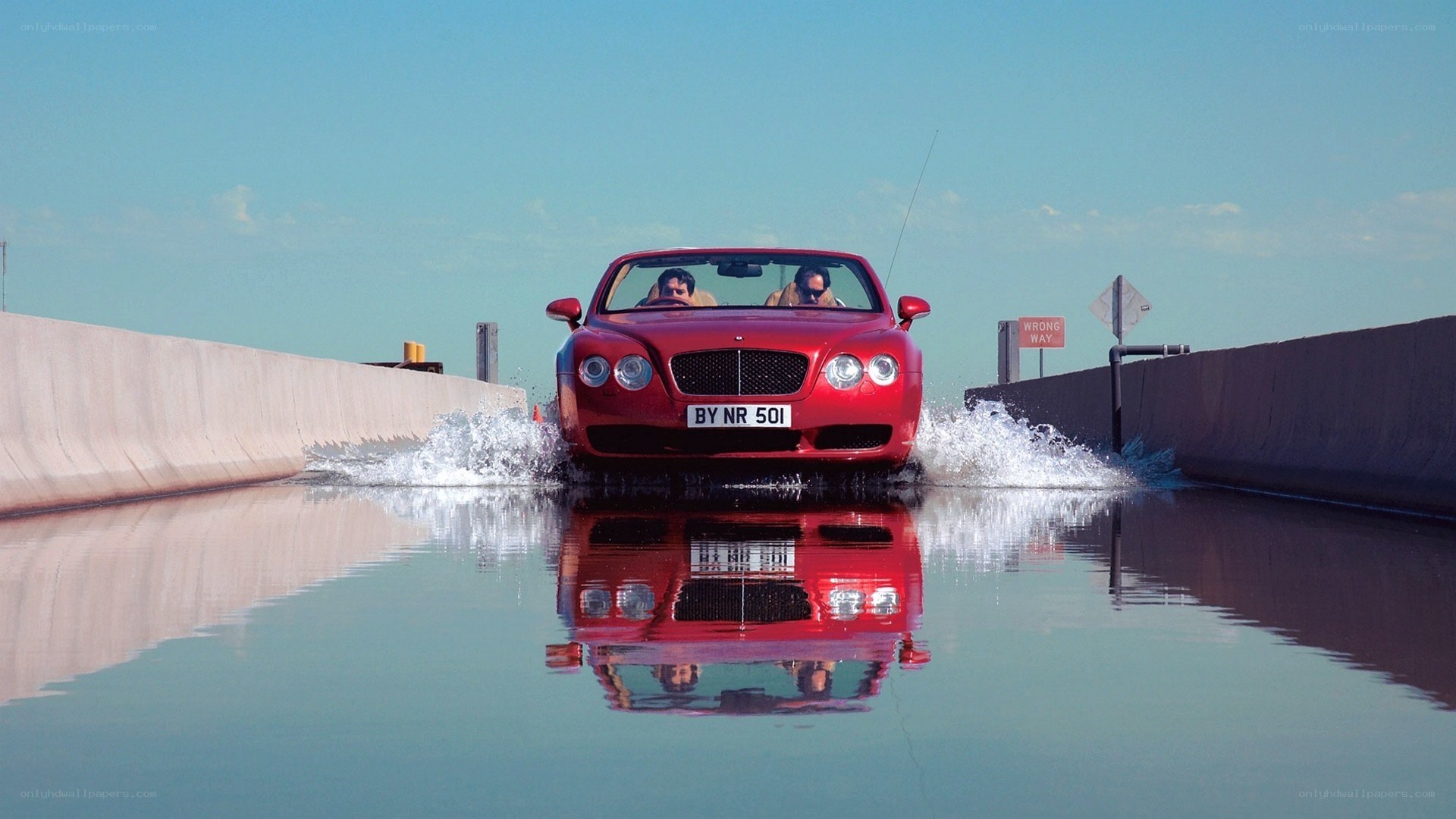 Red car driving through water