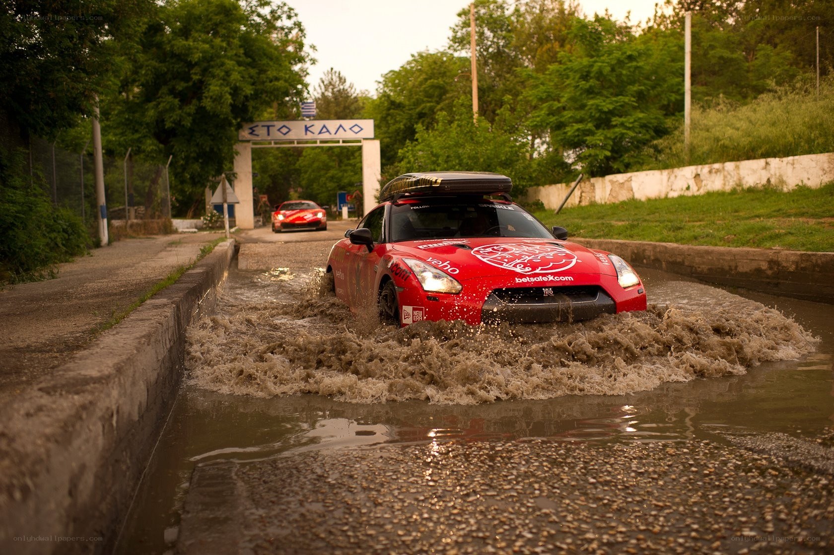 Red car driving through water