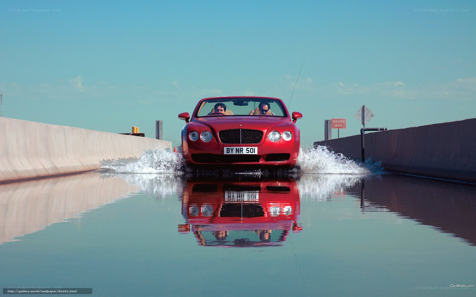 Red car driving through water