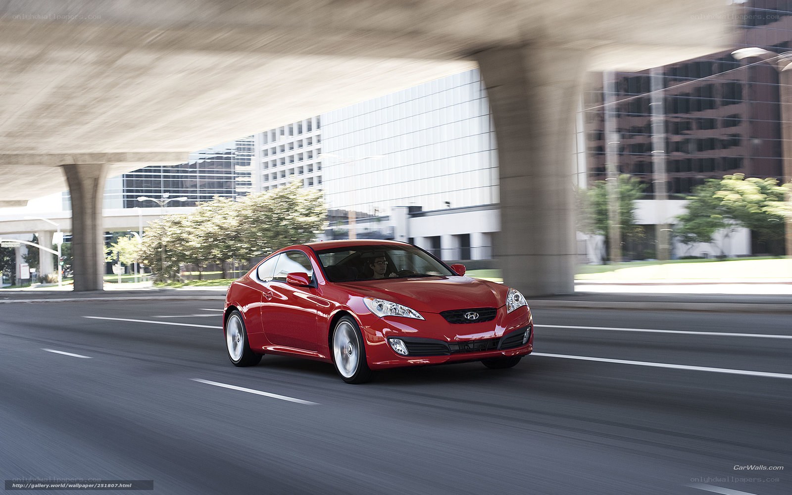 Red car driving under overpass
