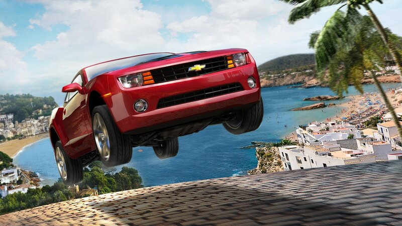 Red car flying over coastal town