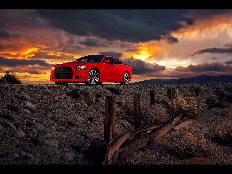 Red car in desert at sunset