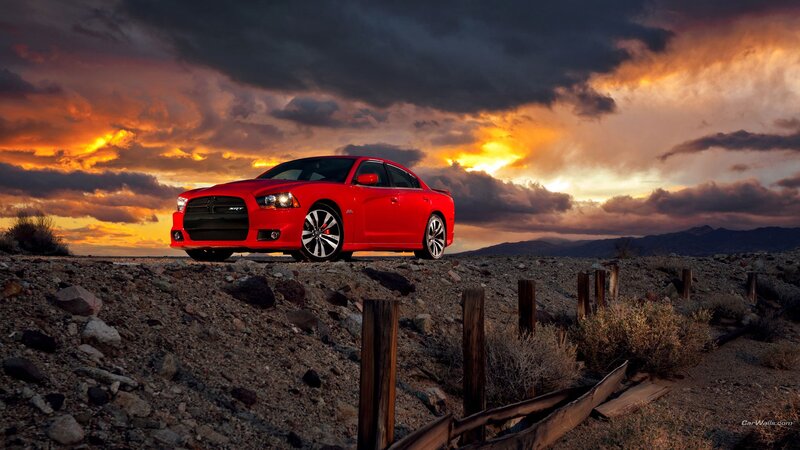 Red car in desert at sunset