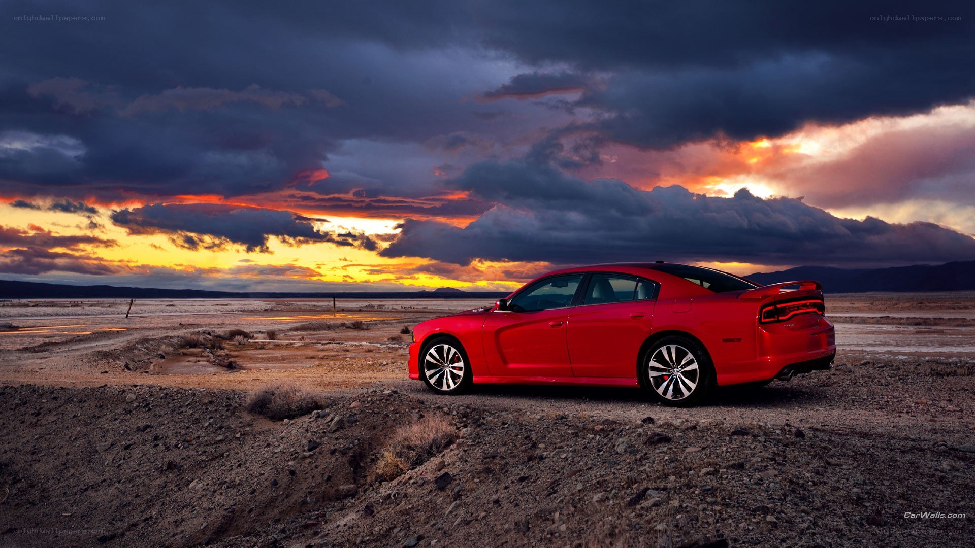Red car in desert at sunset