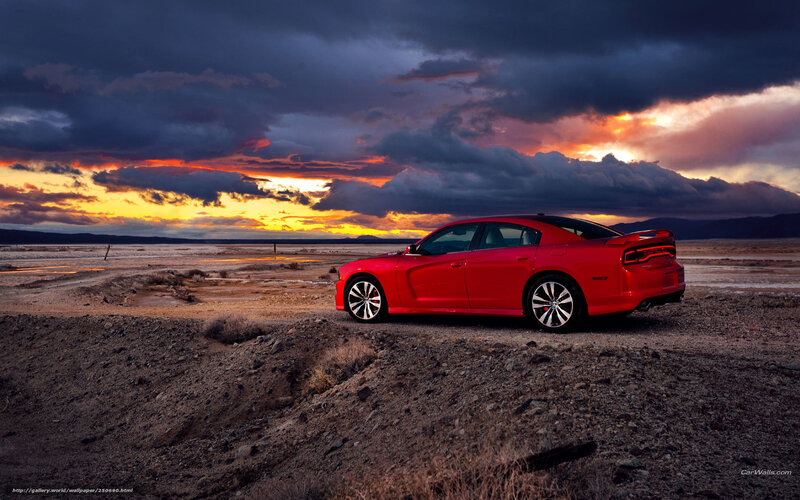 Red car in desert at sunset