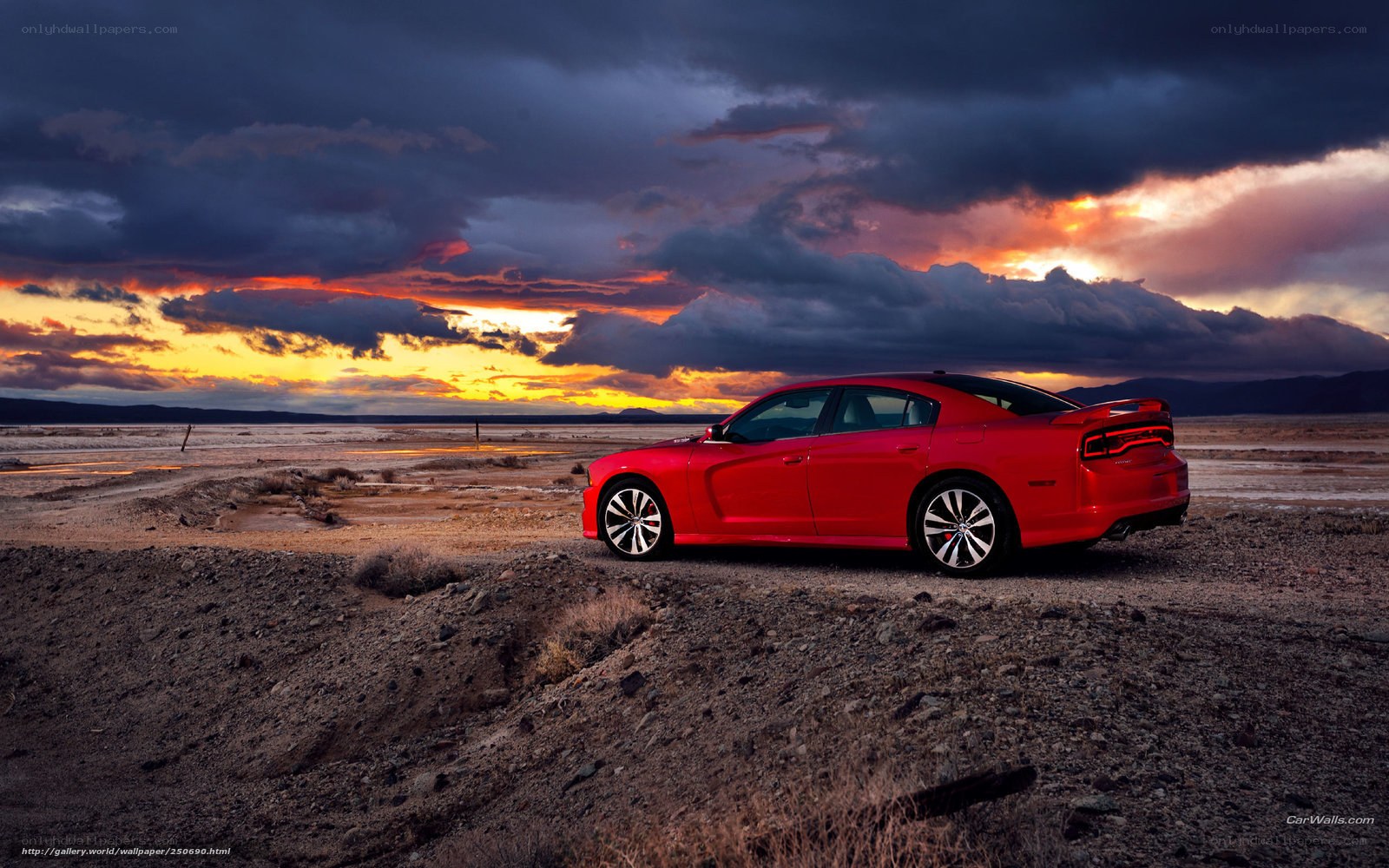 Red car in desert at sunset