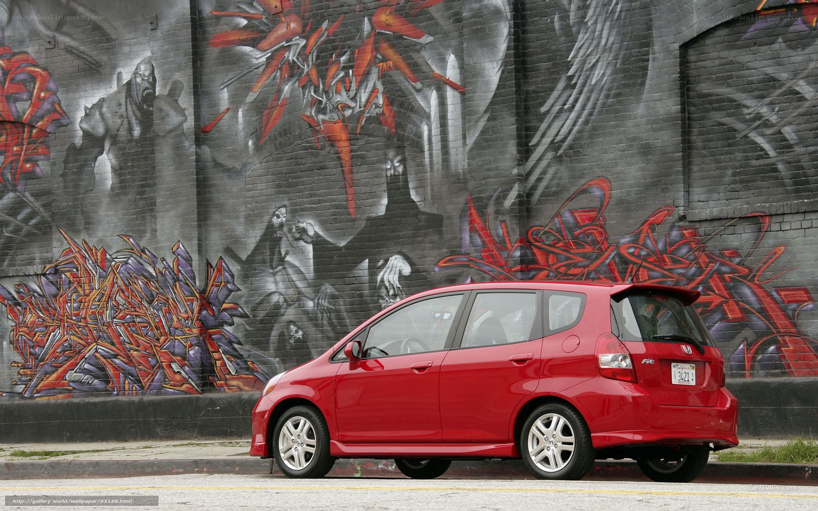 Red car in front of graffiti wall