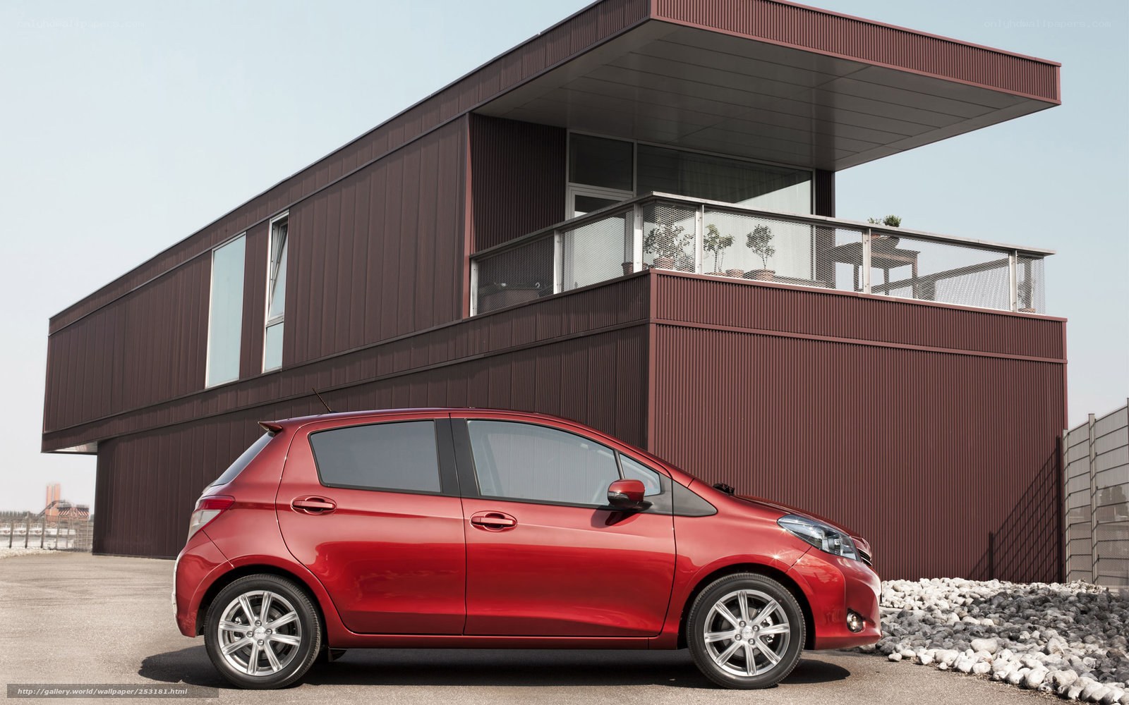 Red car in front of modern house