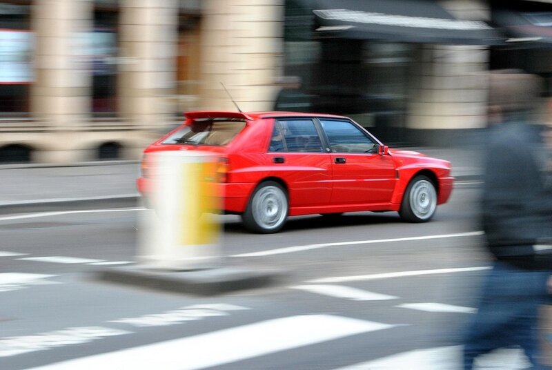 Red car in motion on city street