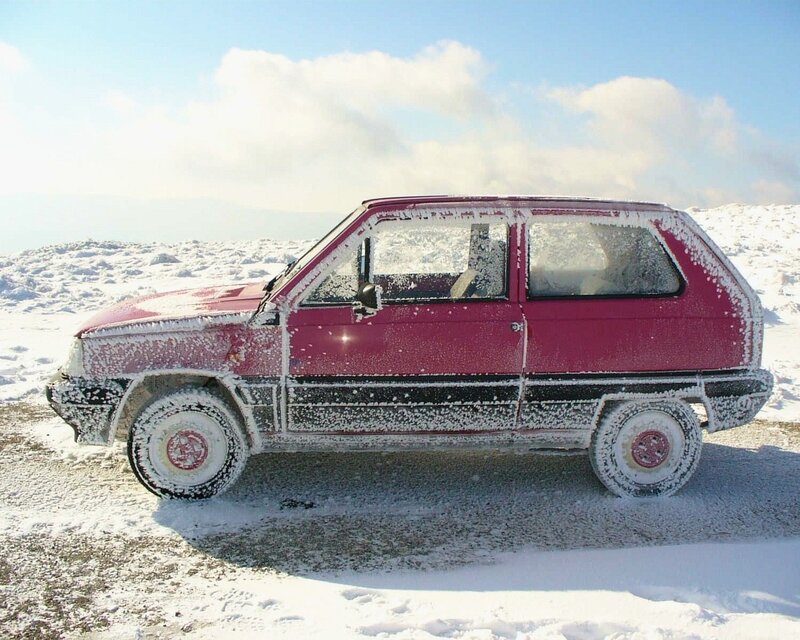 Red car in snowy landscape