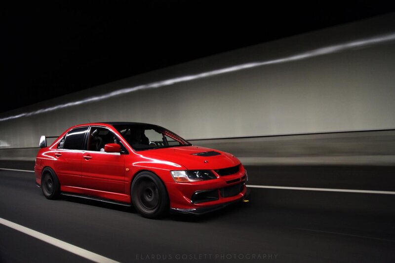 Red car in tunnel at night