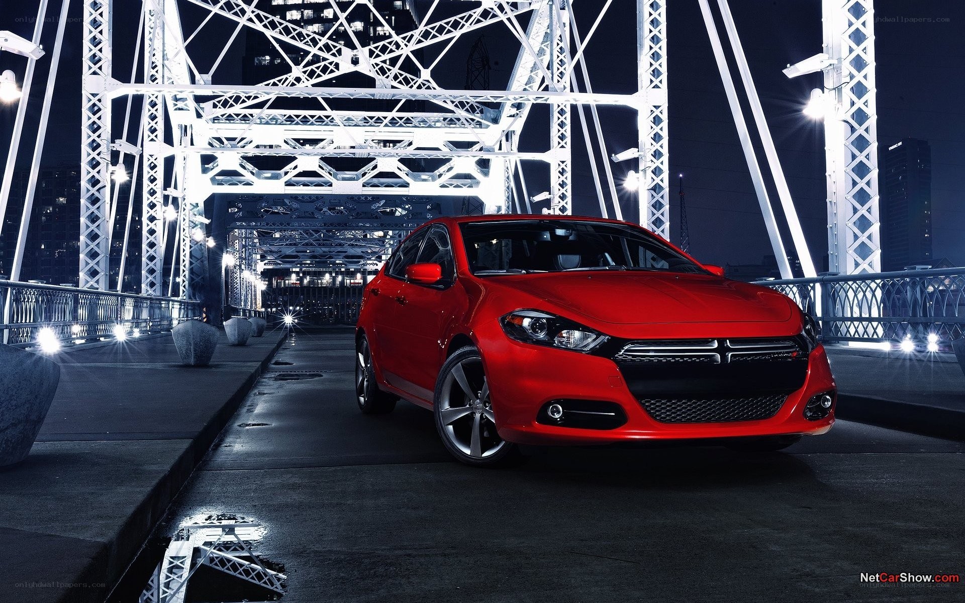 Red car on a bridge at night