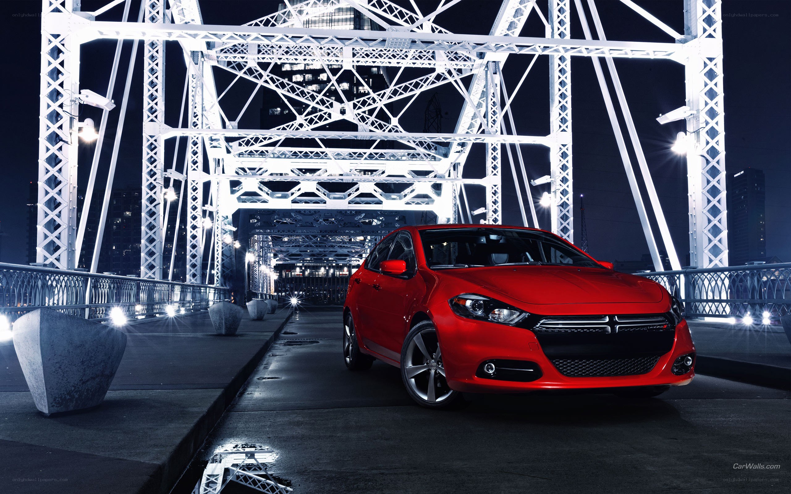 Red car on a bridge at night