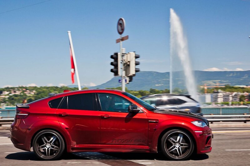 Red car on a bridge with fountain
