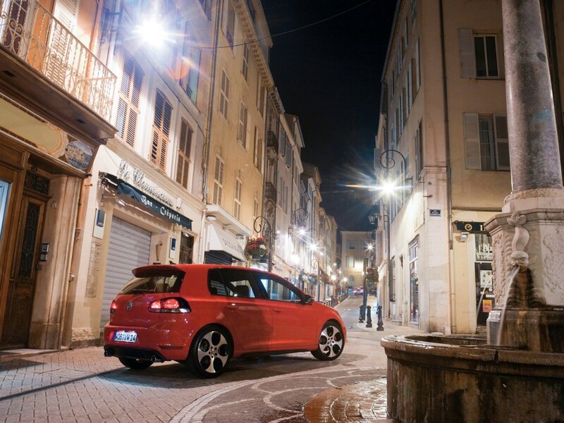 Red car on a city street at night