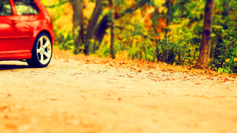 Red car on a forest path