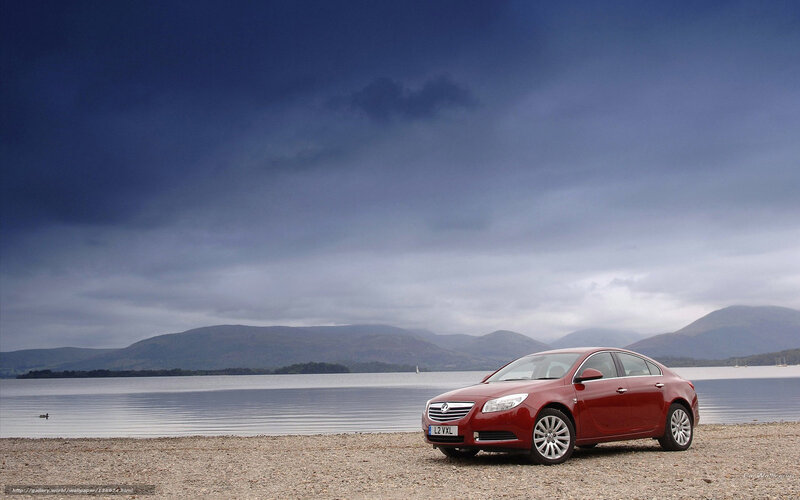 Red car on a lakeside beach