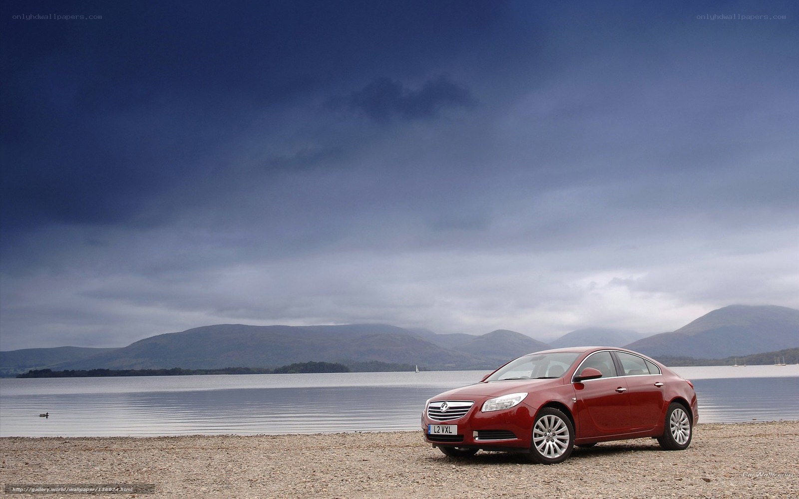 Red car on a lakeside beach