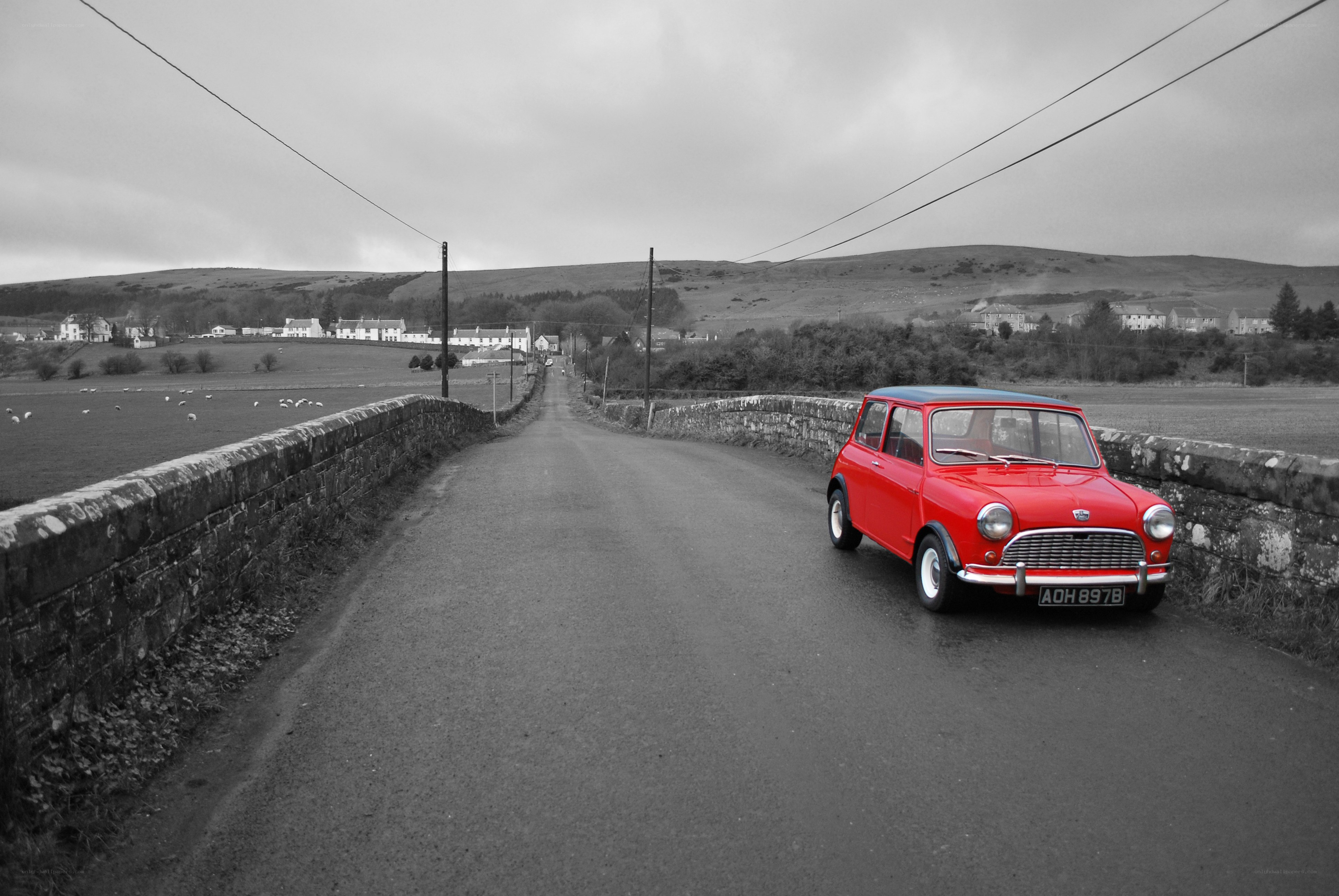 Red car on a rural bridge
