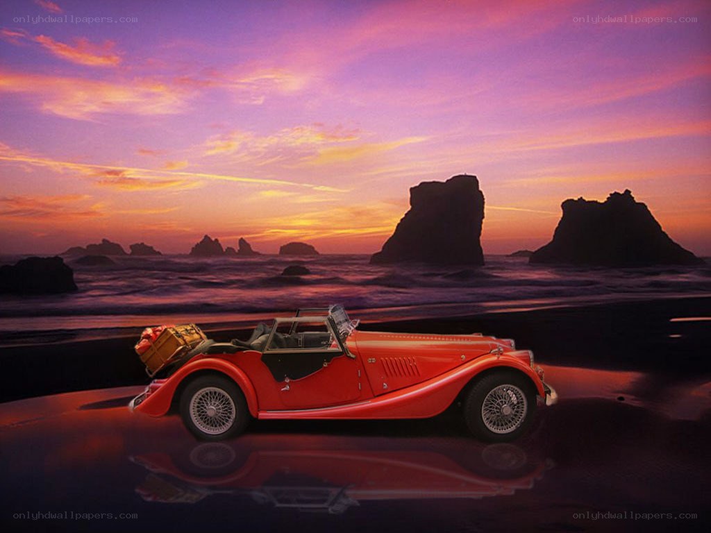 Red car on beach at sunset