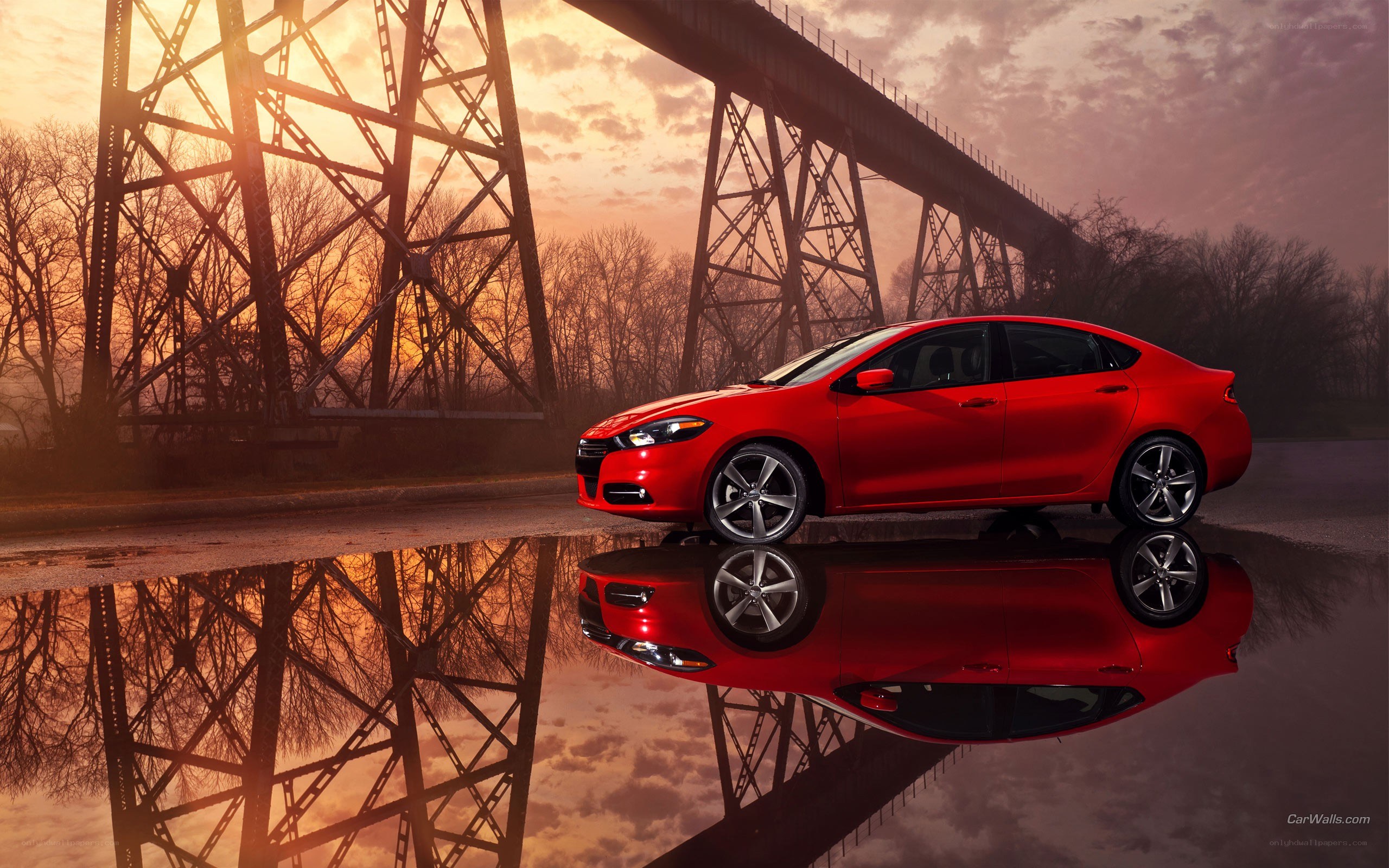 Red car on bridge at sunset