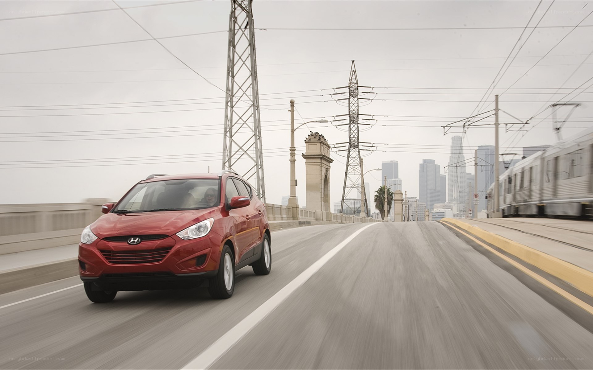 Red car on bridge with city view