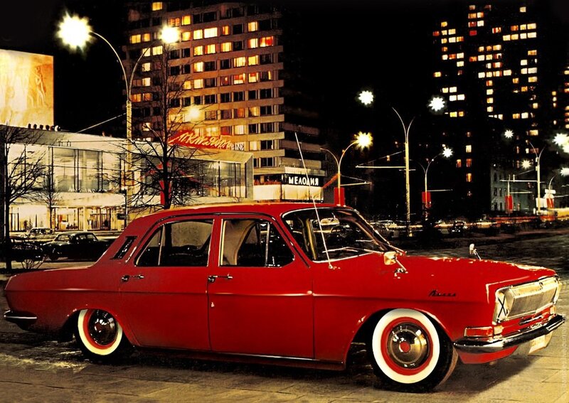 Red car on city street at night