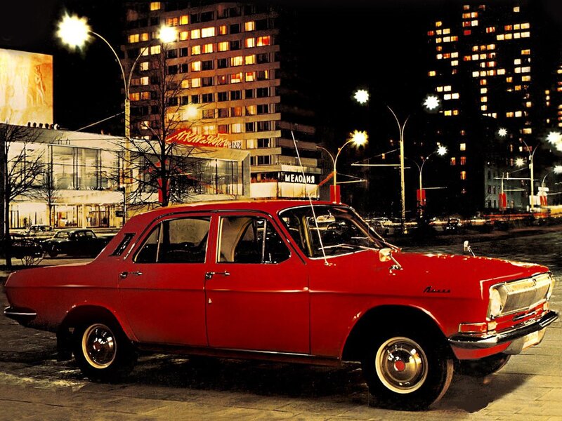 Red car on city street at night