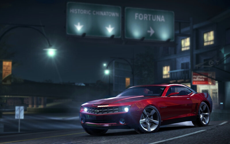 Red car on city street at night