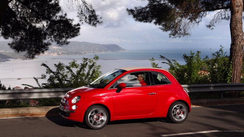 Red car on coastal road