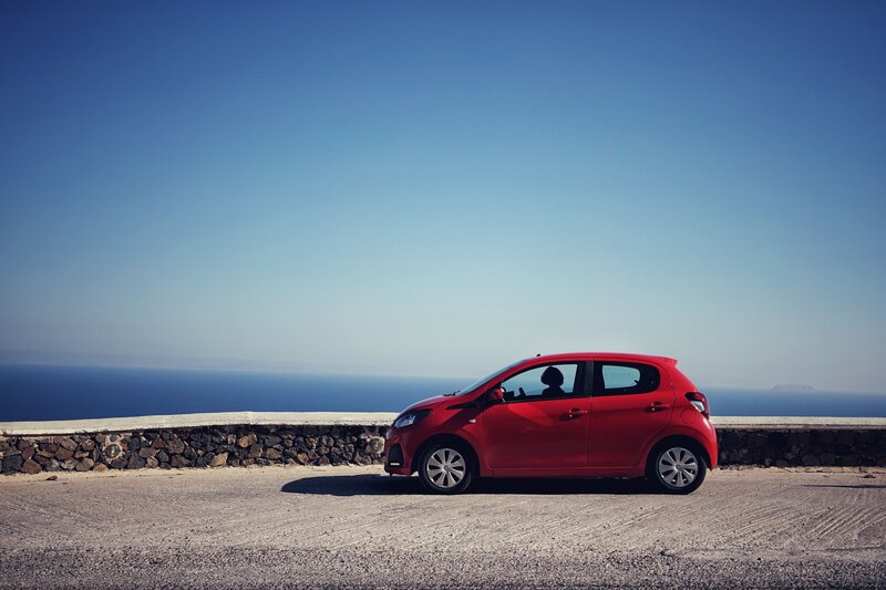 Red Car on Coastal Road — Serene