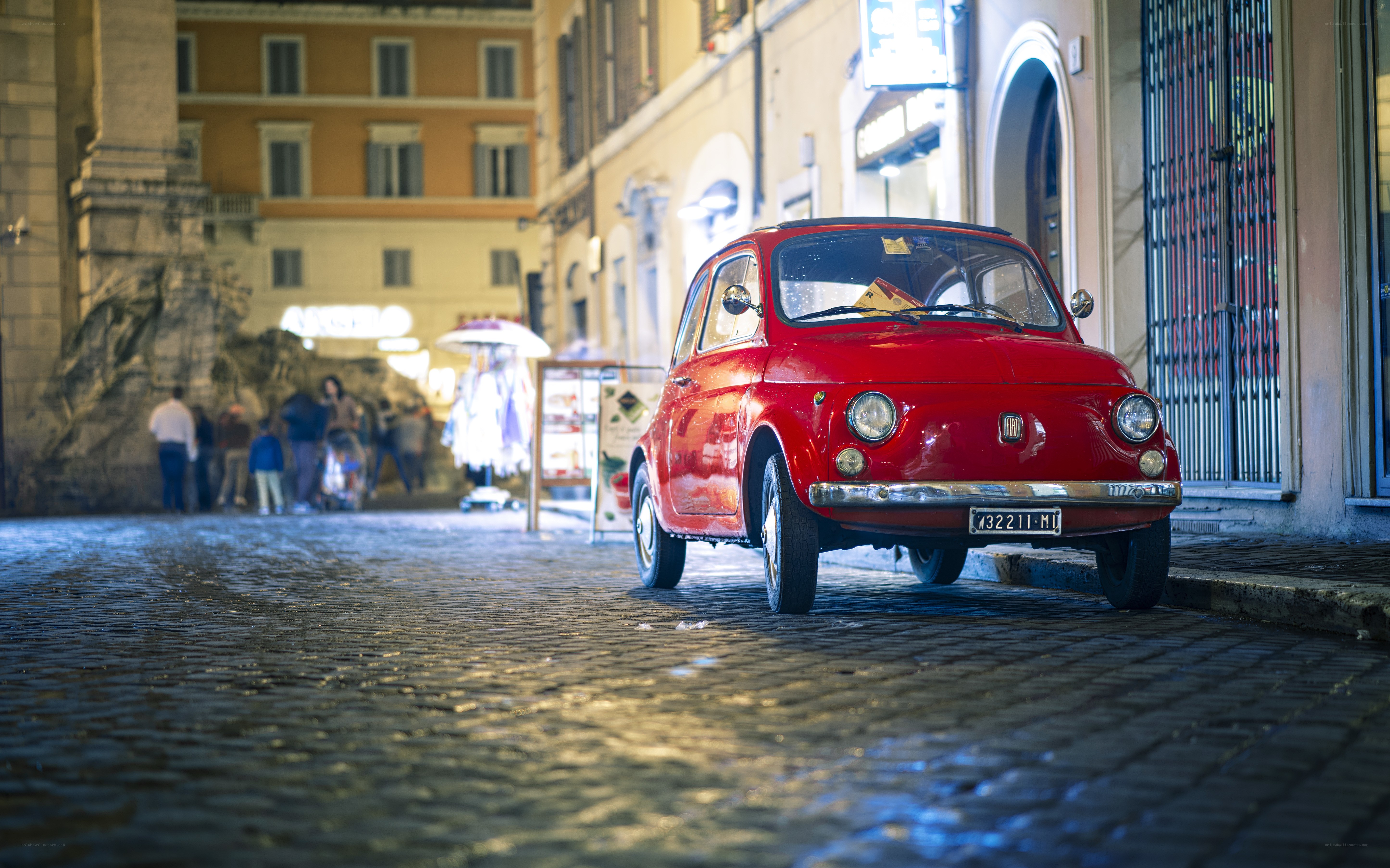 Red car on cobblestone street