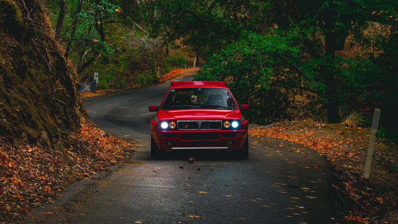 Red Car on Forest Road — Dramatic