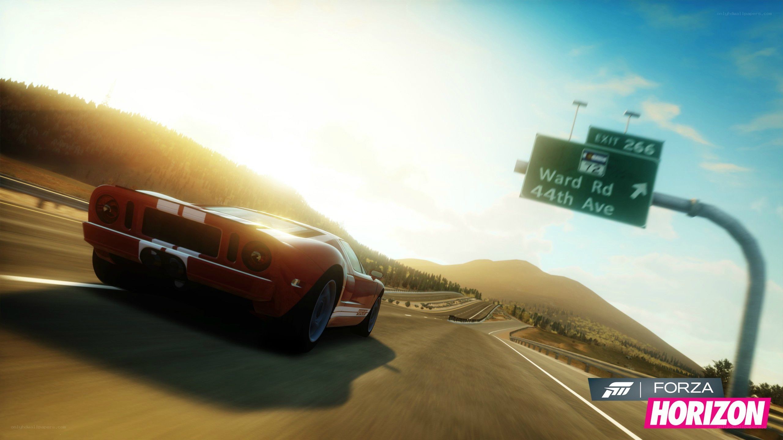 Red car on highway at sunset
